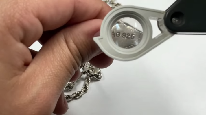marca o sello "925" en una cadena de plata vista a travez de una lupa